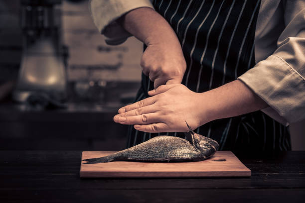 Chef cutting the fish on a board