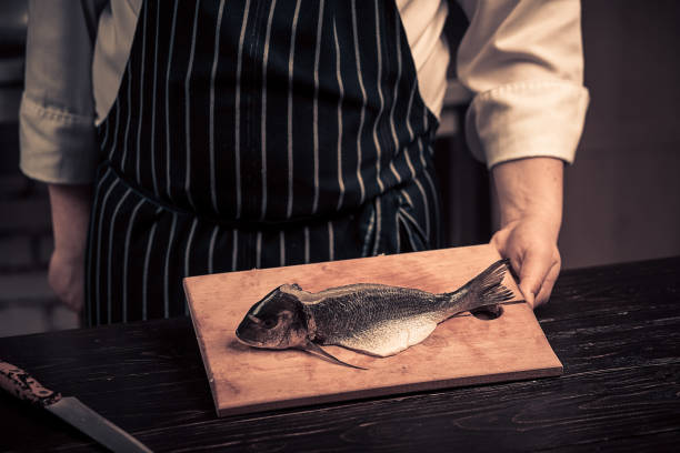 Chef cutting the fish on a board