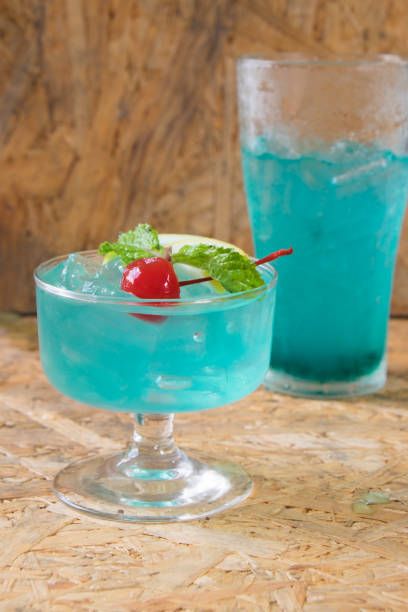 istock A glass with a blue lagoon alcohol cocktail on wood table 669243878