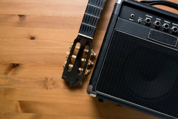 istock Guitar amplifier and old classical guitar on wood table 669244228