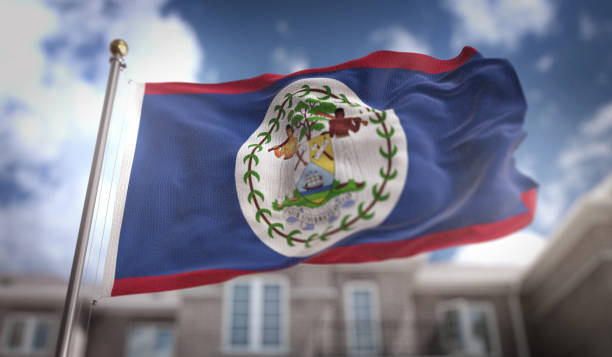 белиз флаг 3d рендеринг на синем небе строительство фон - flag of belize стоковые фото и изображения