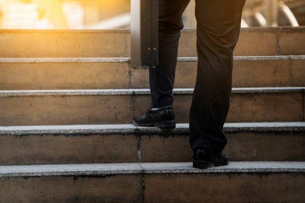 istock Businessman climbing up a concrete staircase concept on success 669247064