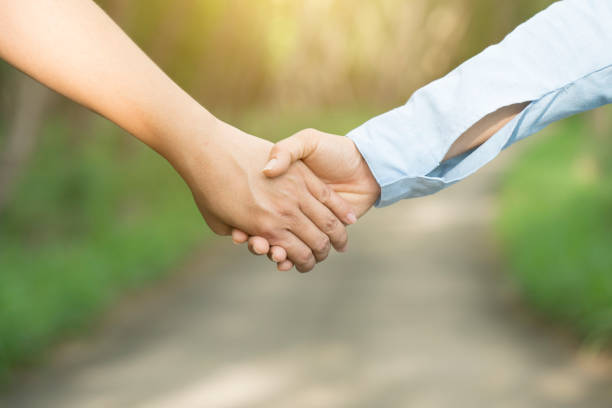 istock Lovers couple holding hands in a forest 669247096