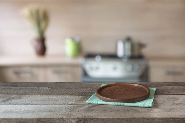 istock Blurred and abstract background. Empty wooden tabletop with tray and defocused modern kitchen background for display or montage your products. 669250502
