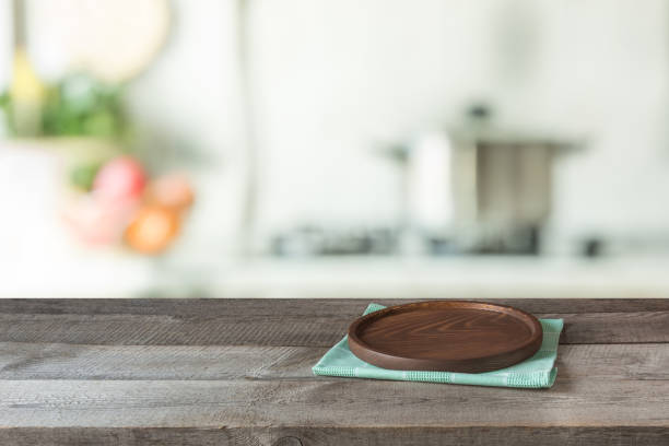 istock Blurred and abstract background. Empty wooden tabletop with tray and defocused modern kitchen background for display or montage your products. 669250512