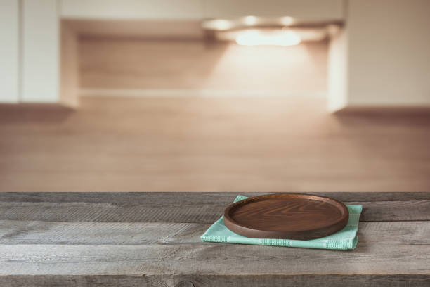 istock Blurred and abstract background. Empty wooden tabletop with tray and defocused modern kitchen background for display or montage your products. 669250514