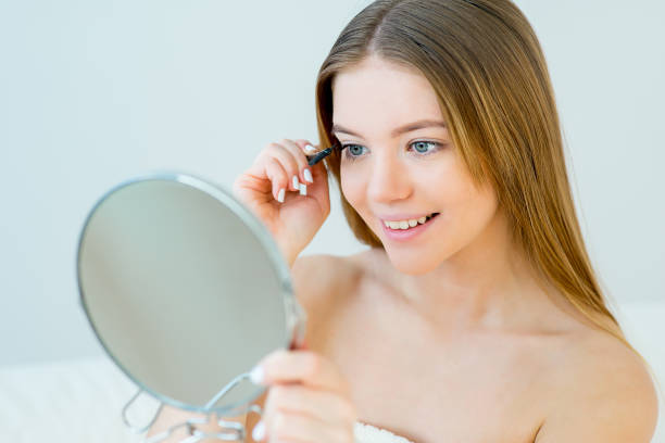 istock Woman curling eyelashes 669250528
