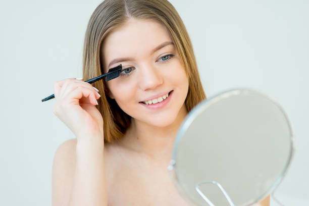istock Woman curling eyelashes 669250572