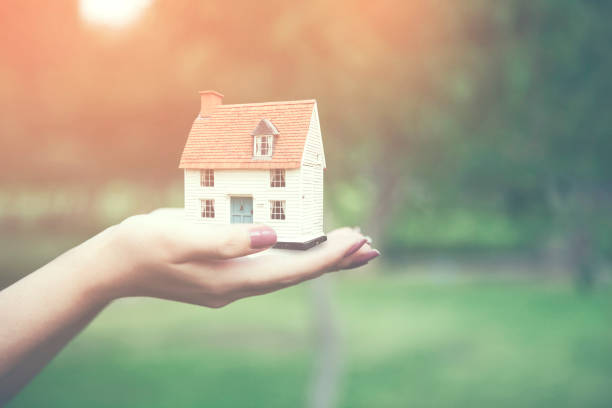 istock woman holding home model, loan concept 669257240