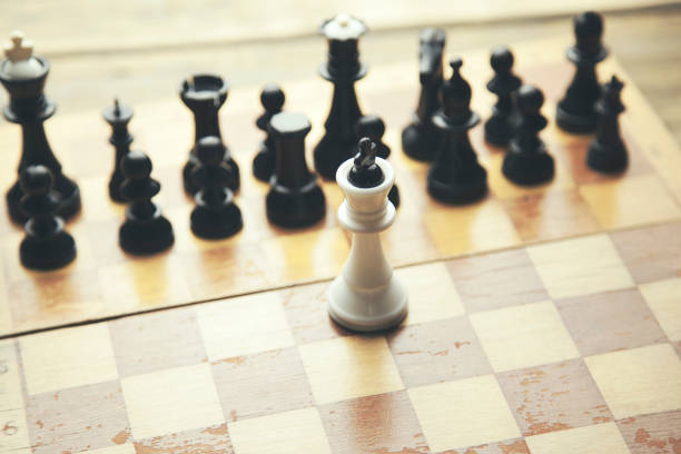 istock Fallen king pieces surrounded by the other color chess pieces 669257310