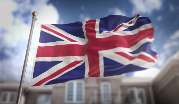istock United Kingdom Flag 3D Rendering on Blue Sky Building Background 669257544