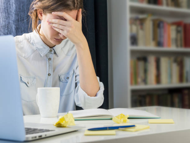 istock Tired or exhausted person sitting at desk 669266444
