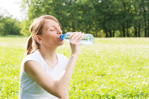 istock Young girl drinking water from a bottle in nature 669280822