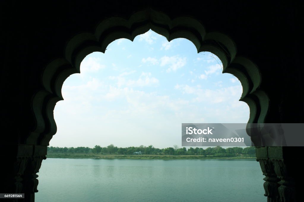 Window view of river Narmada in Maheshwar, India Maheshwar is a small religious and historical town in India. It's considered a sacred place in Hindu religion and is famous for it's Ghats and fort. Maheshwar town was built by Rani Ahilyabai Holkar on the banks of river Narmada. It was the capital of the Malwa during the Maratha Holkar reign till1818, when the capital was shifted to Indore  by King. Architecture Stock Photo