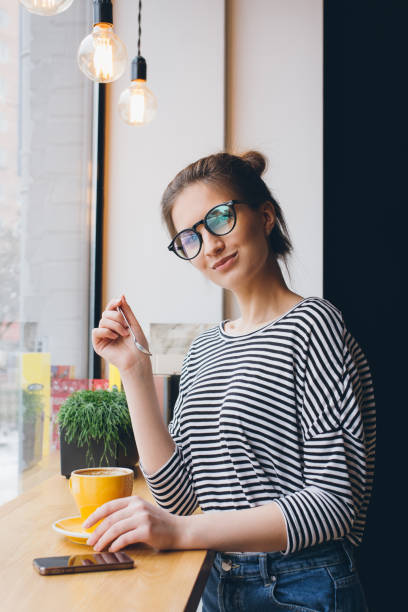 istock Girl in glasses drinking coffee 669291314