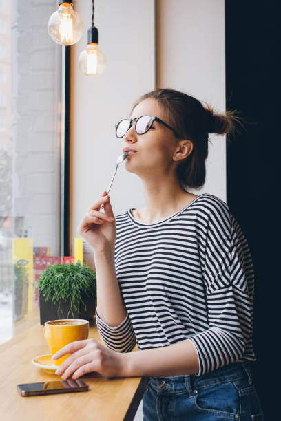 istock Girl in glasses drinking coffee 669298456