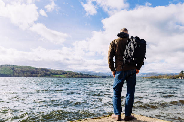 istock Man stood at the end of a jetty overlooking a lake. 669305372