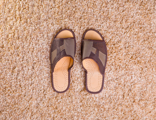 istock Men's slippers on the fleecy carpet 669313200