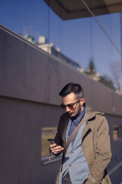 istock Young businessman looking a phone on a way to work 669318510