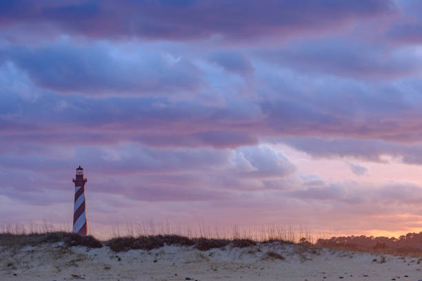Sunset and spectacular colorful clouds on the gorgeous Cape hatteras Lighthouse on the Outer Banks Sunset and spectacular colorful clouds on the gorgeous Cape hatteras Lighthouse on the Outer Banks cape hatteras stock pictures, royalty-free photos & images
