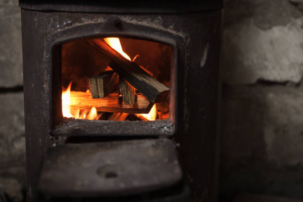Fire burning in small black iron stove. Closeup photo with selective focus