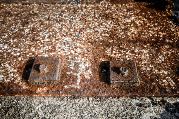 Rusty fragments of a hexagonal bolt head steel plate near the sea