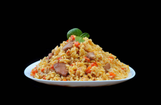 istock pilaf with meat and carrots on white plate and black background 669338704