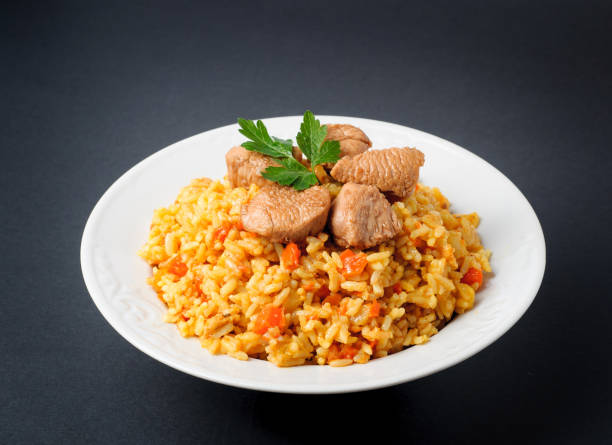 istock rice with meat and vegetables on a white plate. Pilaf isolated on gray background 669339186