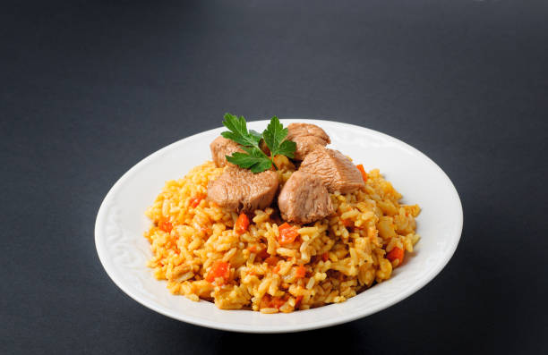 istock rice with meat and vegetables on a white plate. Pilaf isolated on gray background 669339242