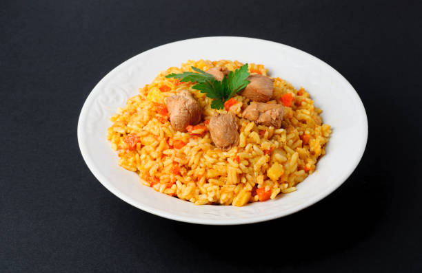 istock A delicious pilaf wit meat in a plate on dark background 669339424
