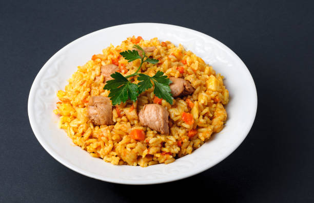 istock white plate of cooked rice with meat on dark background 669339504