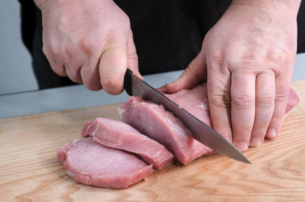 istock man cutting raw meat at the kitchen 669349206