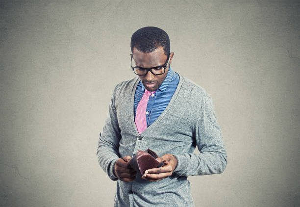 Young man looking into his empty wallet has no money Young man looking into his empty wallet has no money over spend stock pictures, royalty-free photos & images