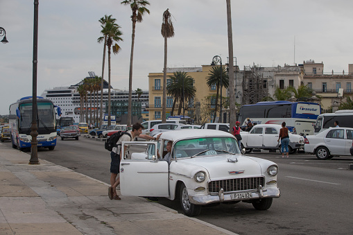 A tourist is bargain with the taxi driver regarding the ride.