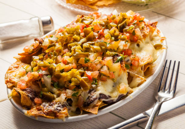 istock Mexican food: nachos with melted cheese, tomato and jalapeno peppers. 669356856