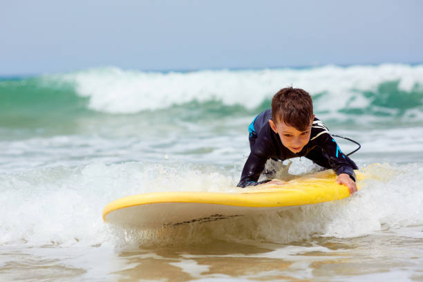 istock Young boy child swimming with surfboard 669363864