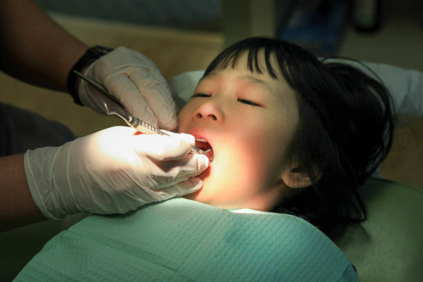 Young Asian girl is having her dental checked by a dentist.