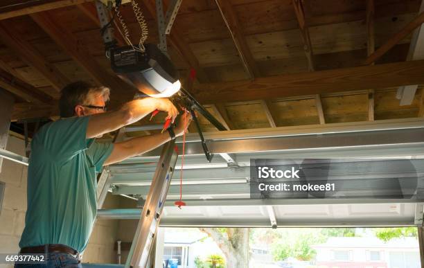 Professional Automatic Garage Door Opener Repair Service Technician Man Working Stock Photo - Download Image Now