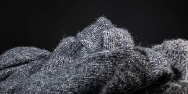 istock Isolated close-up handmade gray cashmere wool fabric texture on a dark background. 669384062