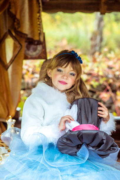 uma menina linda segurando o chapéu do cilindro com orelhas como um coelho nas mãos na mesa - little girls alice in wonderland child fairy tale - fotografias e filmes do acervo