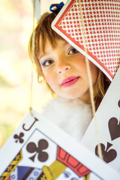 retrato de menina bonita com grande jogo de cartas - little girls alice in wonderland child fairy tale - fotografias e filmes do acervo