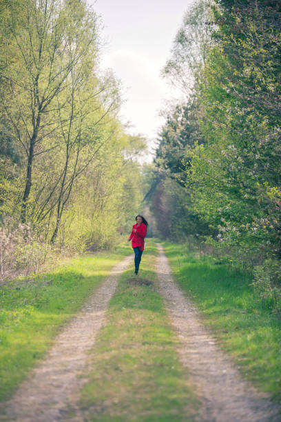 istock Women in a red coat running 669396920
