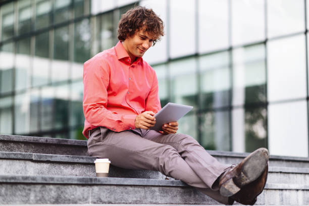 istock Cheerful businessman in modern European city using digital tablet 669402932