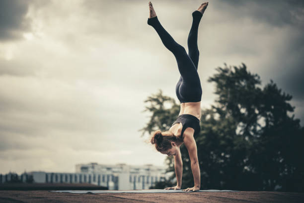 istock Young woman doing yoga exercises at sunset 669403756