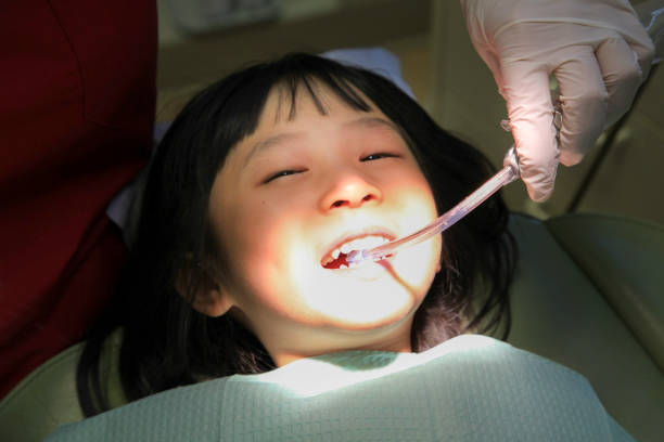 Young Asian girl is having her dental checked by a dentist.