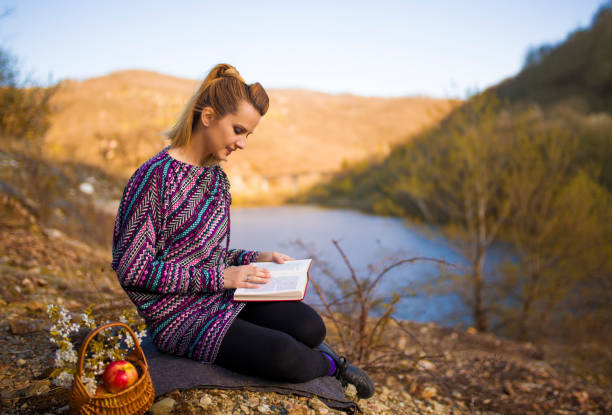 Woman enjoy in spring and read a book at lake
