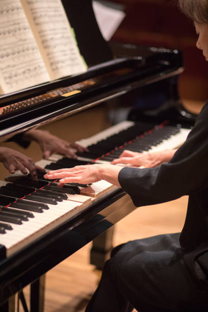 istock Woman playing piano on stage 669412498
