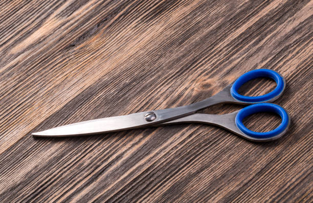 istock scissor on wooden board 669413122