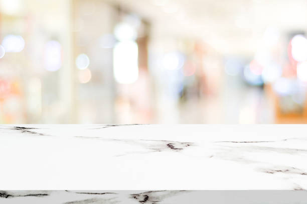 istock Empty white marble table over blur store background, product and food display montage 669423116