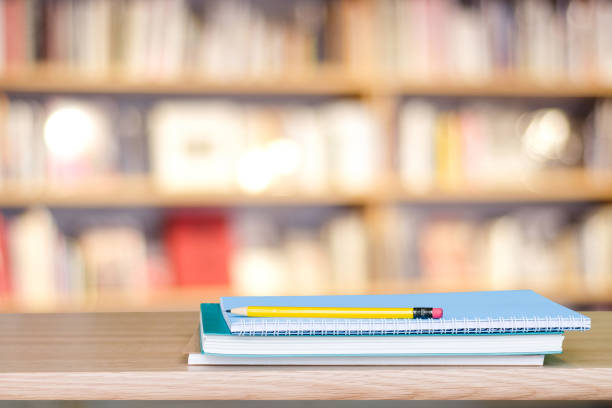 istock Notebook paper and pencil on table over blur book store background, with copy space for display montage, education concept 669423136